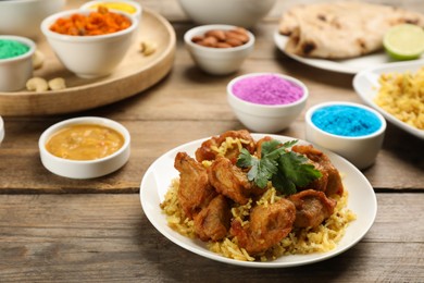 Photo of Traditional Indian food and color powders on wooden table. Holi festival celebration