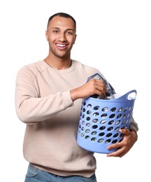 Happy man with basket full of laundry on white background