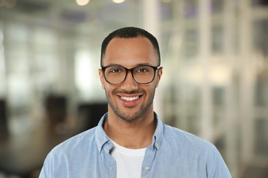 Image of Handsome confident man with eyeglasses in office