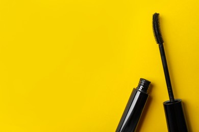 Photo of Mascara on yellow background, flat lay with space for text. Makeup product