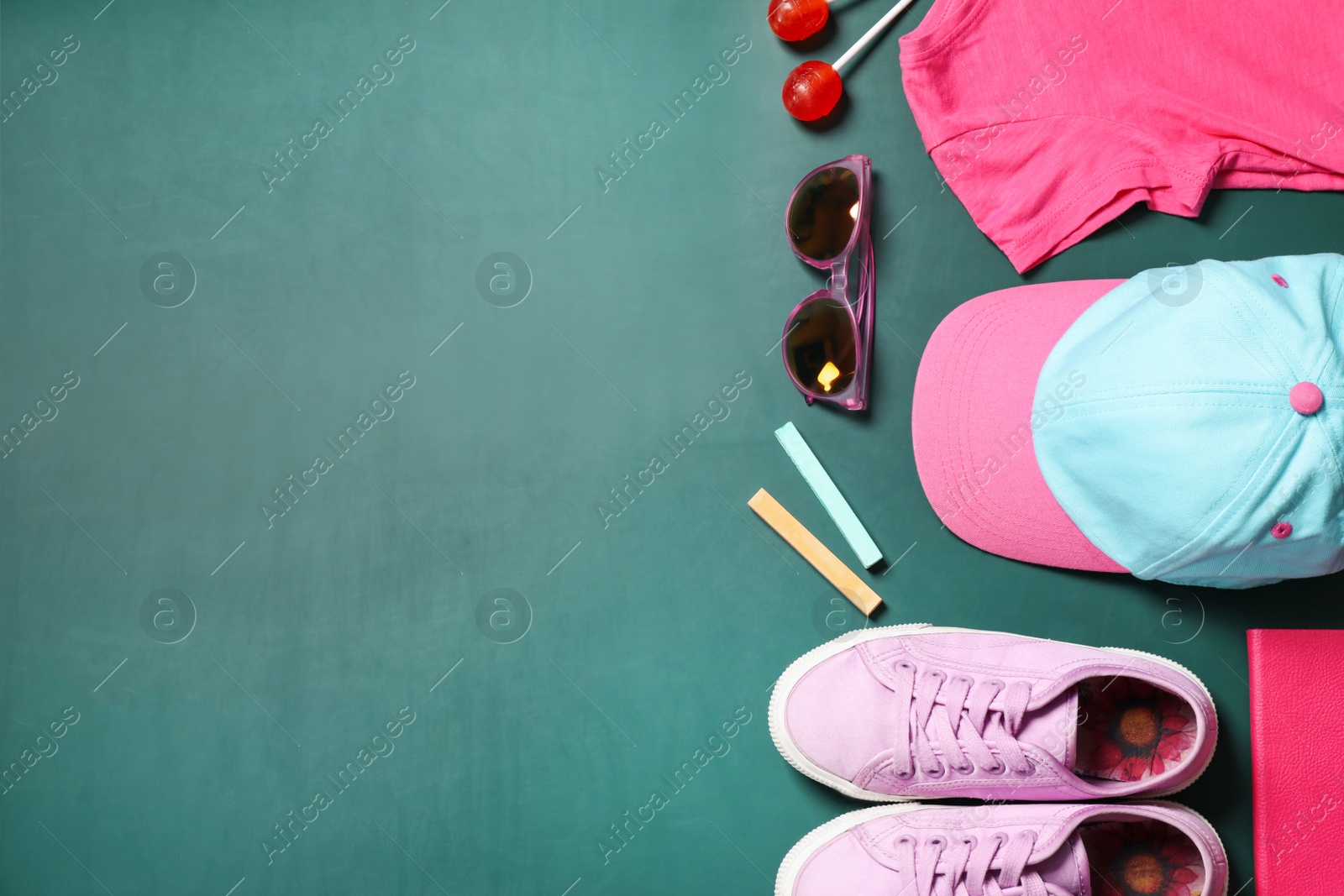 Photo of Different child accessories and space for text on green chalkboard, flat lay. School holidays