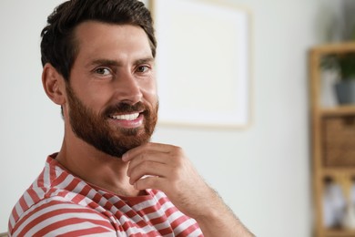 Photo of Portrait of handsome bearded man at home, space for text