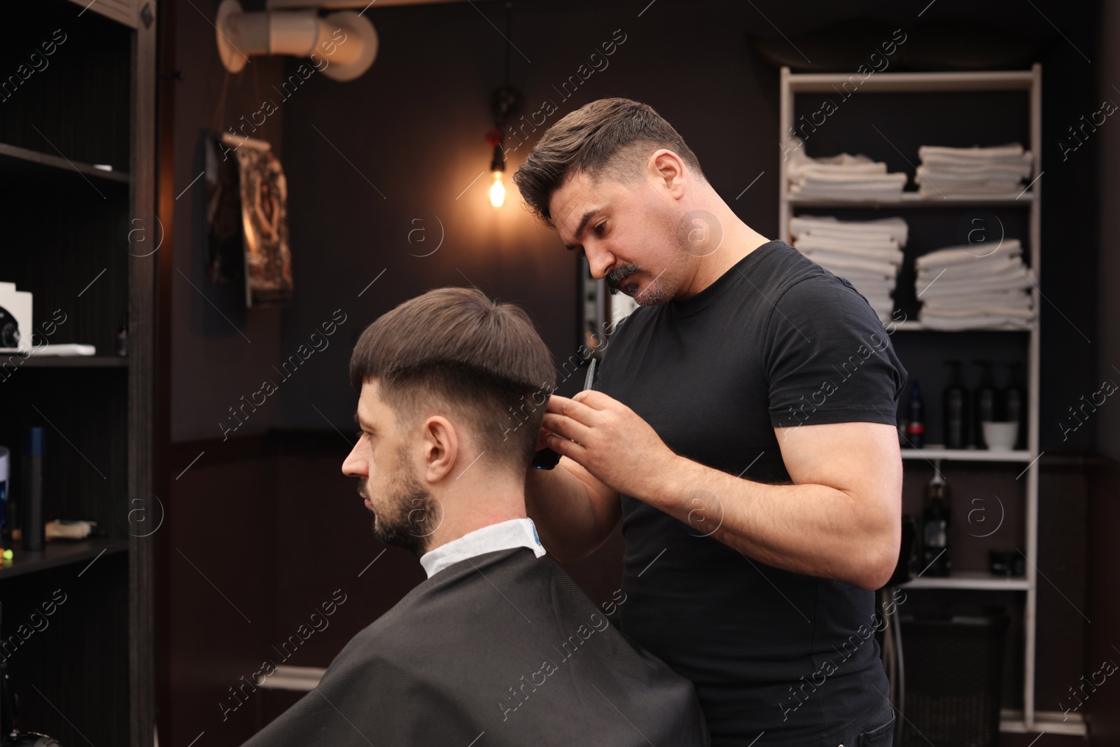 Photo of Professional hairdresser making stylish haircut in barbershop