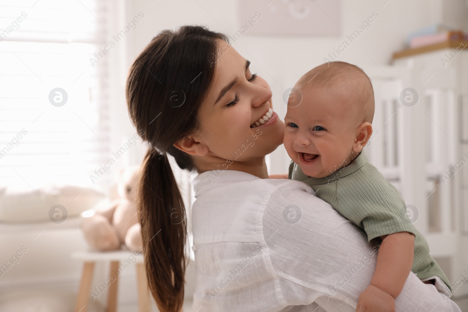 Photo of Happy young mother with her cute baby at home