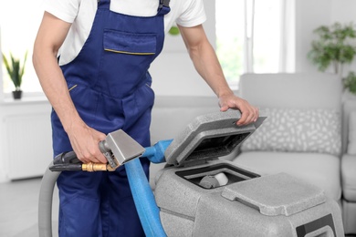 Photo of Dry cleaning worker with professional apparatus indoors