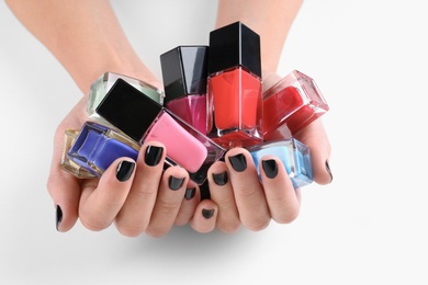 Woman holding nail polish bottles isolated on white, closeup