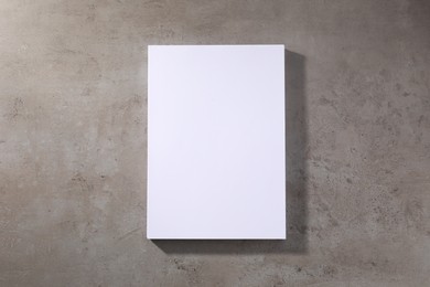 Photo of Stack of blank paper sheets on grey textured table, top view. Space for text