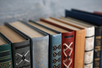 Photo of Stack of hardcover books on grey background, closeup