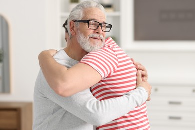 Happy dad and his son hugging at home