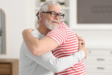 Photo of Happy dad and his son hugging at home