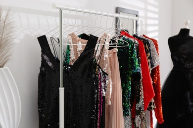 Photo of Rack with collection of beautiful festive clothes indoors