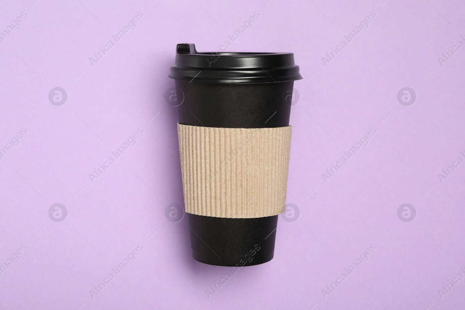 Photo of Takeaway paper coffee cup with cardboard sleeve on violet background, top view