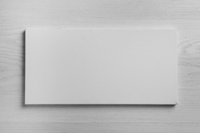Photo of Blank canvas on white wooden background, space for text