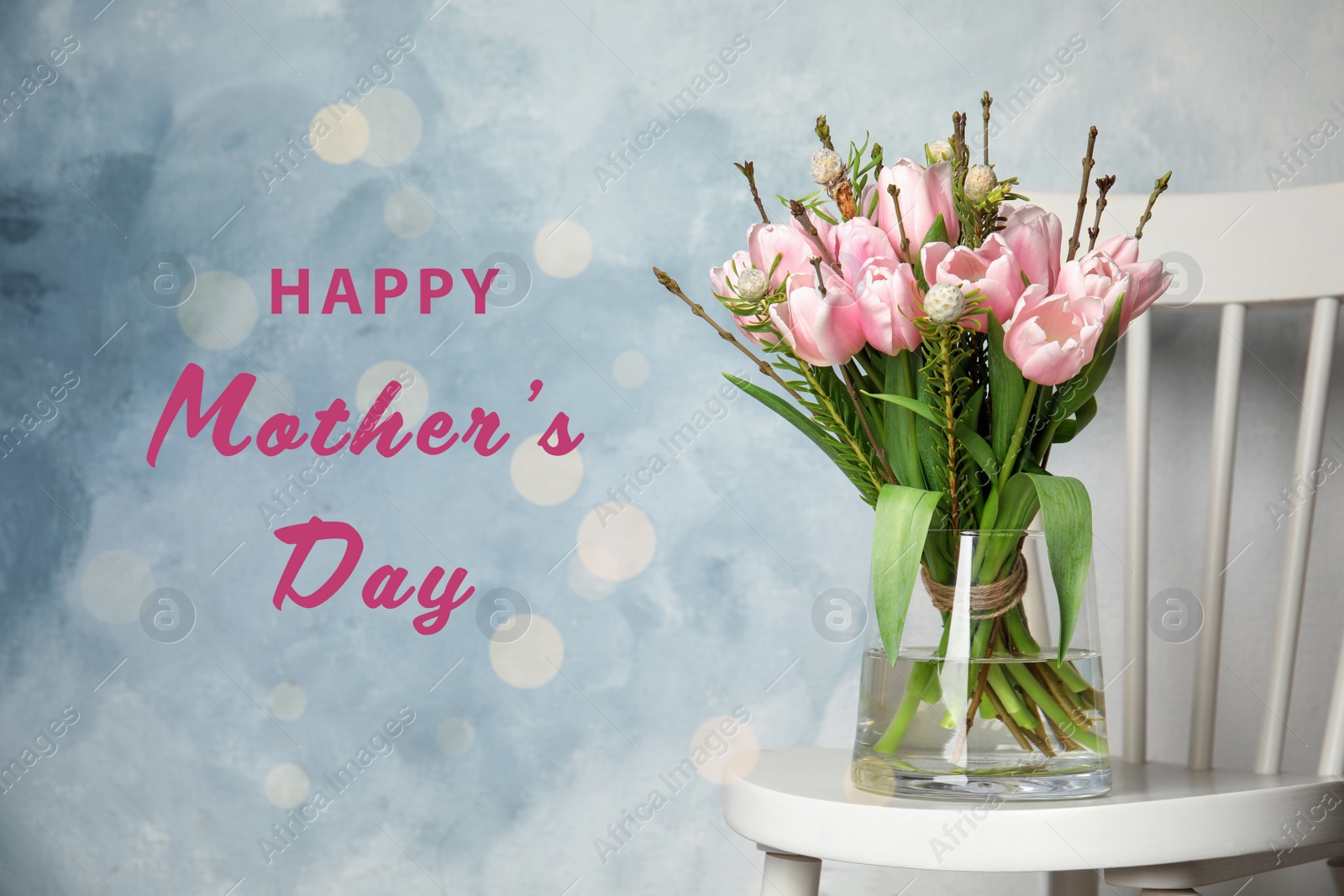 Image of Vase with beautiful tulips on chair and phrase HAPPY MOTHER'S DAY against light blue background