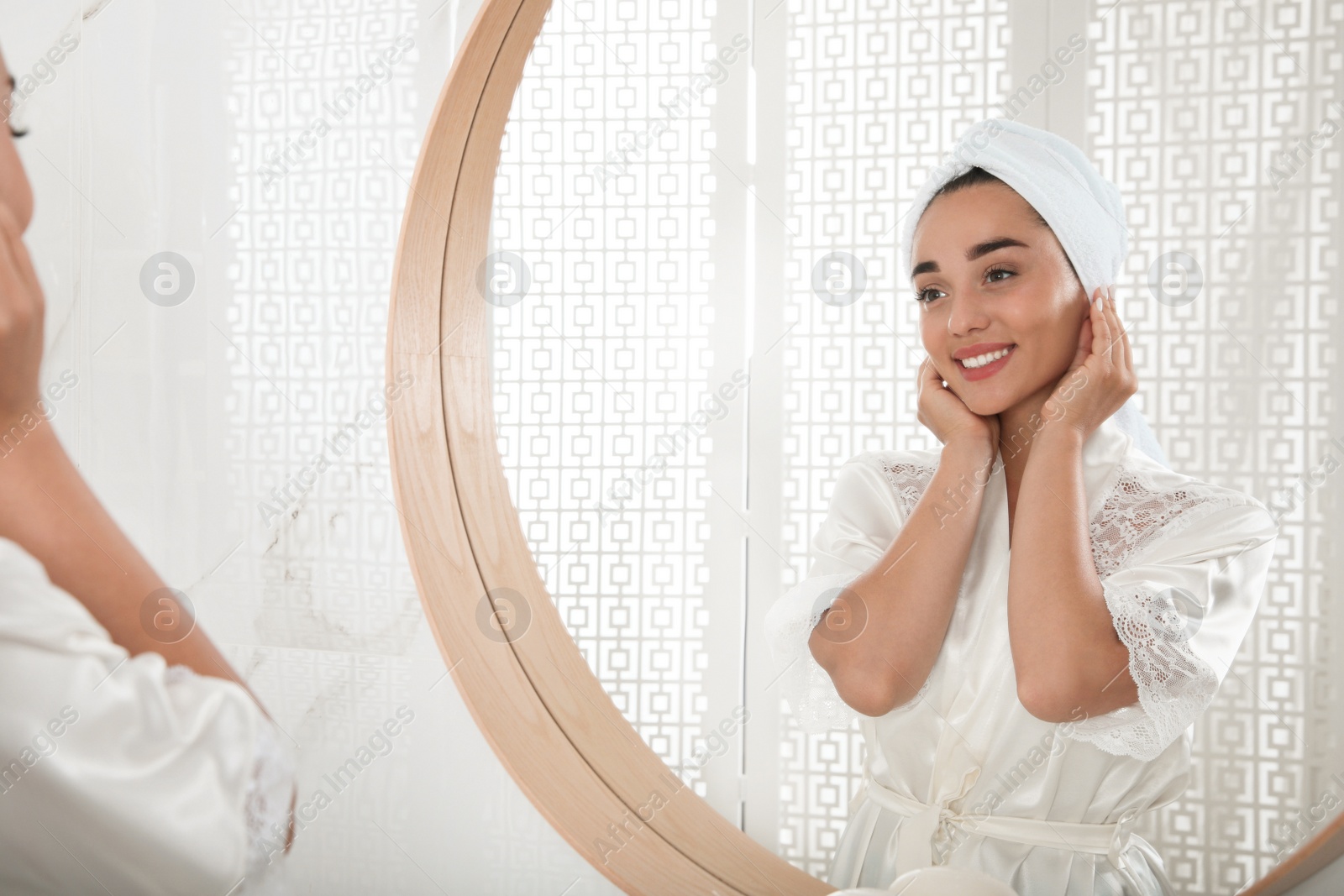 Photo of Beautiful young woman with perfect skin near mirror in bathroom. Facial wash