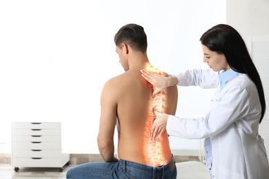 Image of Professional orthopedist examining man in medical office. Spinal pain