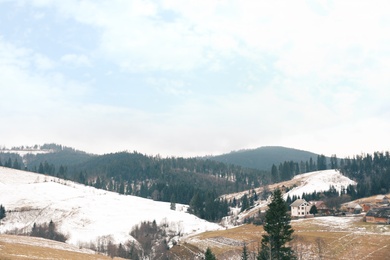 Photo of Beautiful winter landscape with buildings and forest on snowy hills