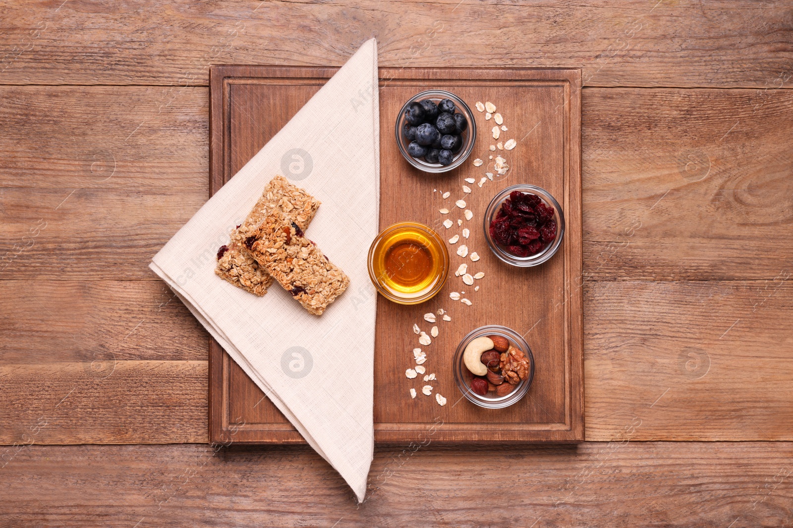 Photo of Tasty granola bars served on wooden table, top view