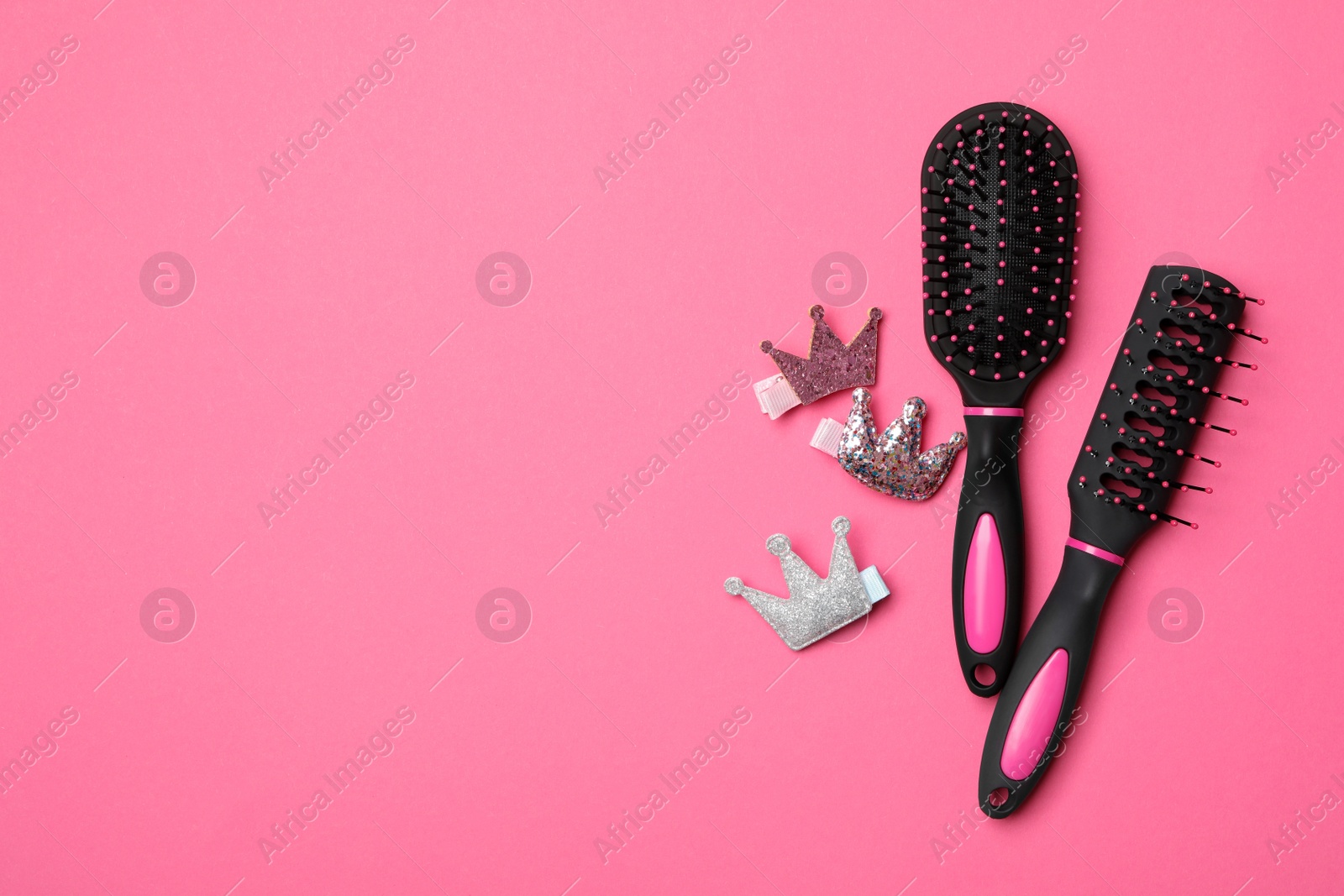 Photo of Flat lay composition with modern hair brushes on pink background, space for text
