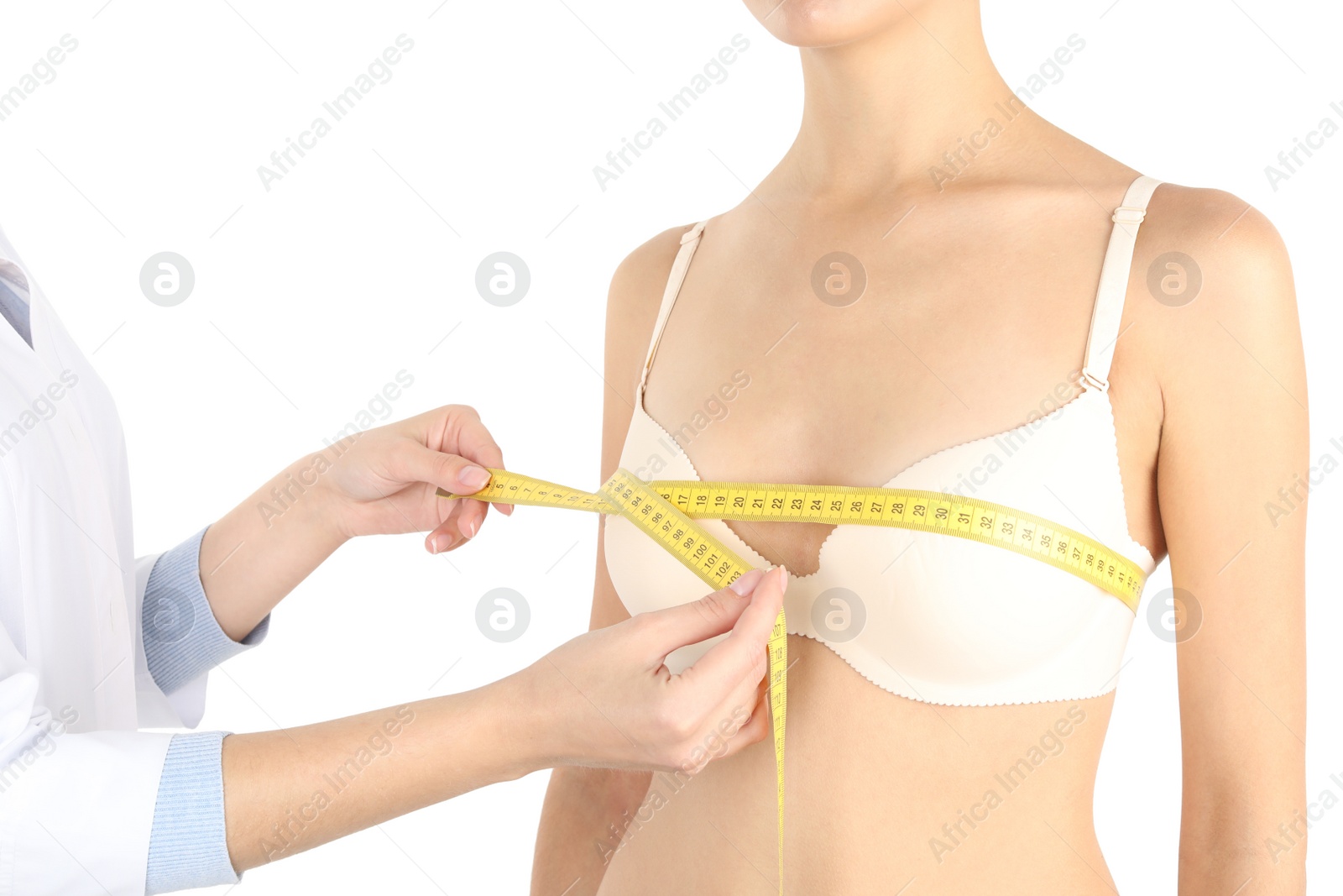 Photo of Doctor measuring size of patient's breast on white background, closeup. Cosmetic surgery