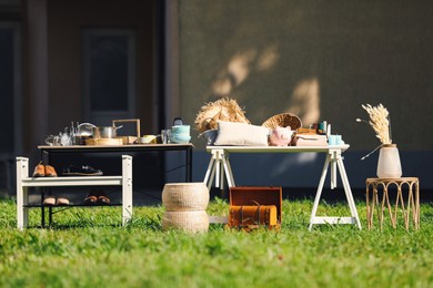 Small tables with many different items on garage sale in yard