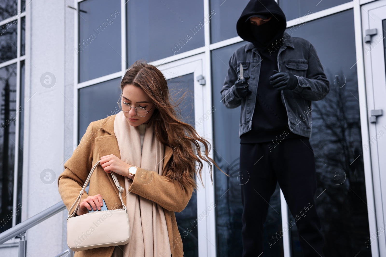 Photo of Man with knife stalking young woman near building