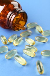 Photo of Jar with vitamin capsules on blue background, closeup