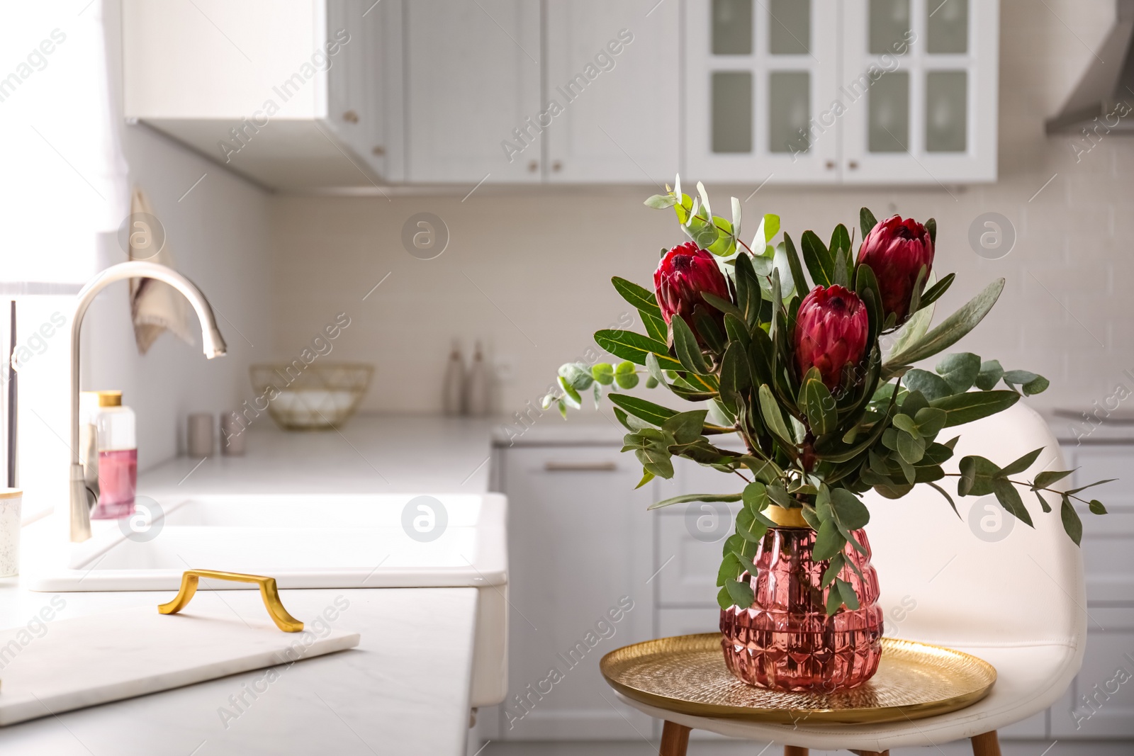 Photo of Bouquet with beautiful protea flowers in kitchen, space for text. Interior design