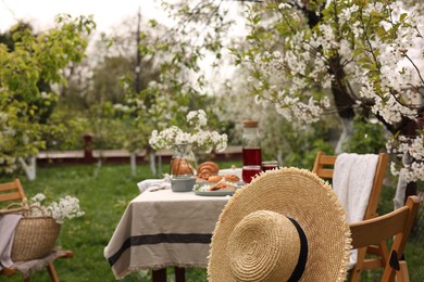 Photo of Stylish table setting with beautiful spring flowers, fruit drink and pie in garden