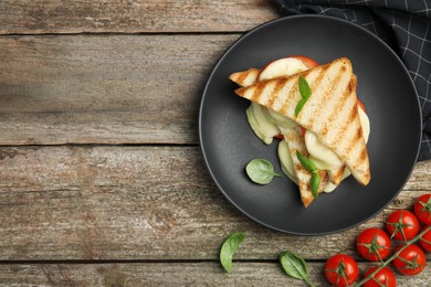 Photo of Delicious grilled sandwiches with mozzarella, tomatoes and basil on wooden table, flat lay. Space for text
