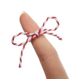 Woman showing index finger with tied bow as reminder on white background, closeup