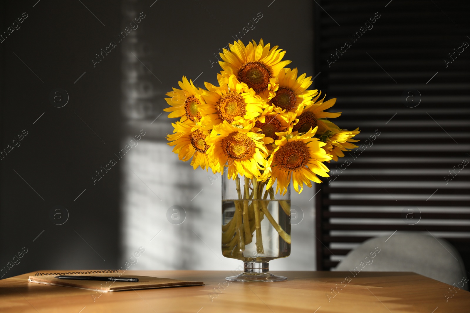 Photo of Bouquet of beautiful sunflowers on table in room