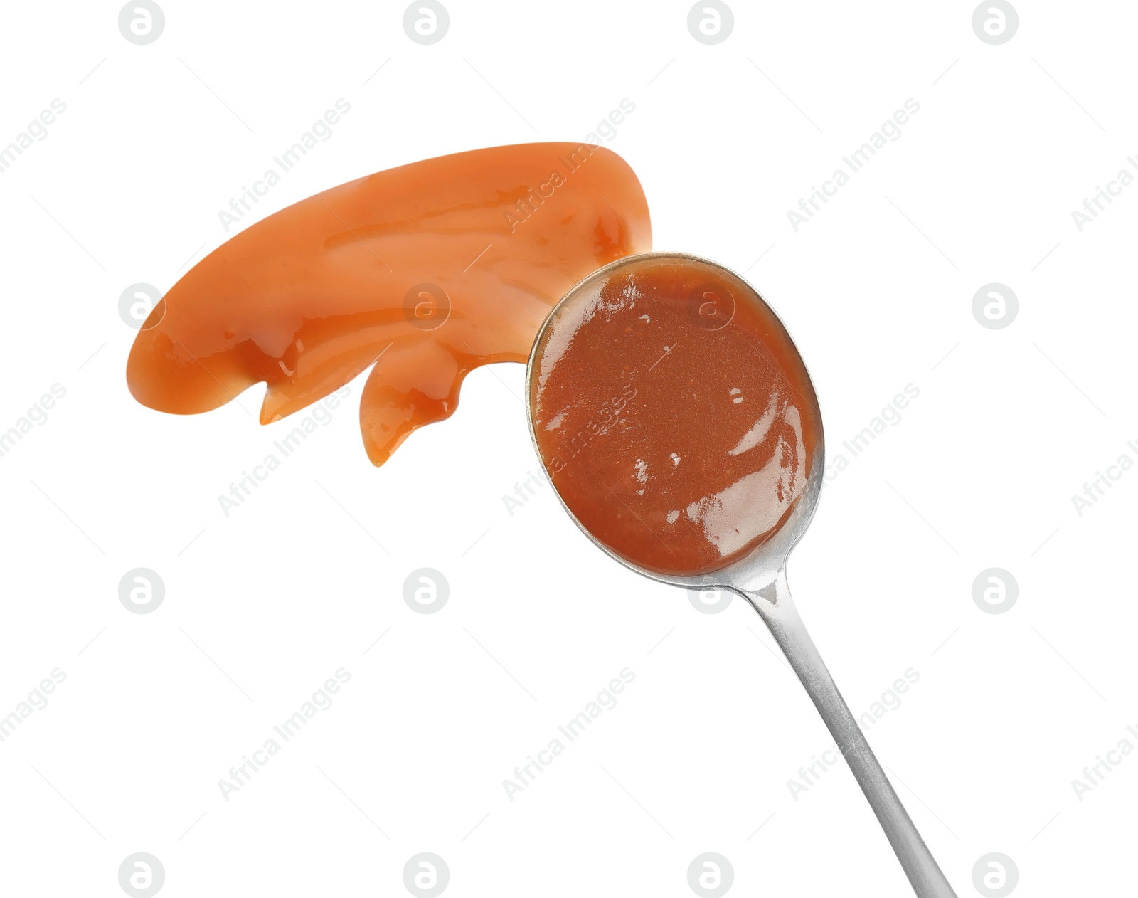 Photo of Spoon and strokes of caramel sauce isolated on white, top view