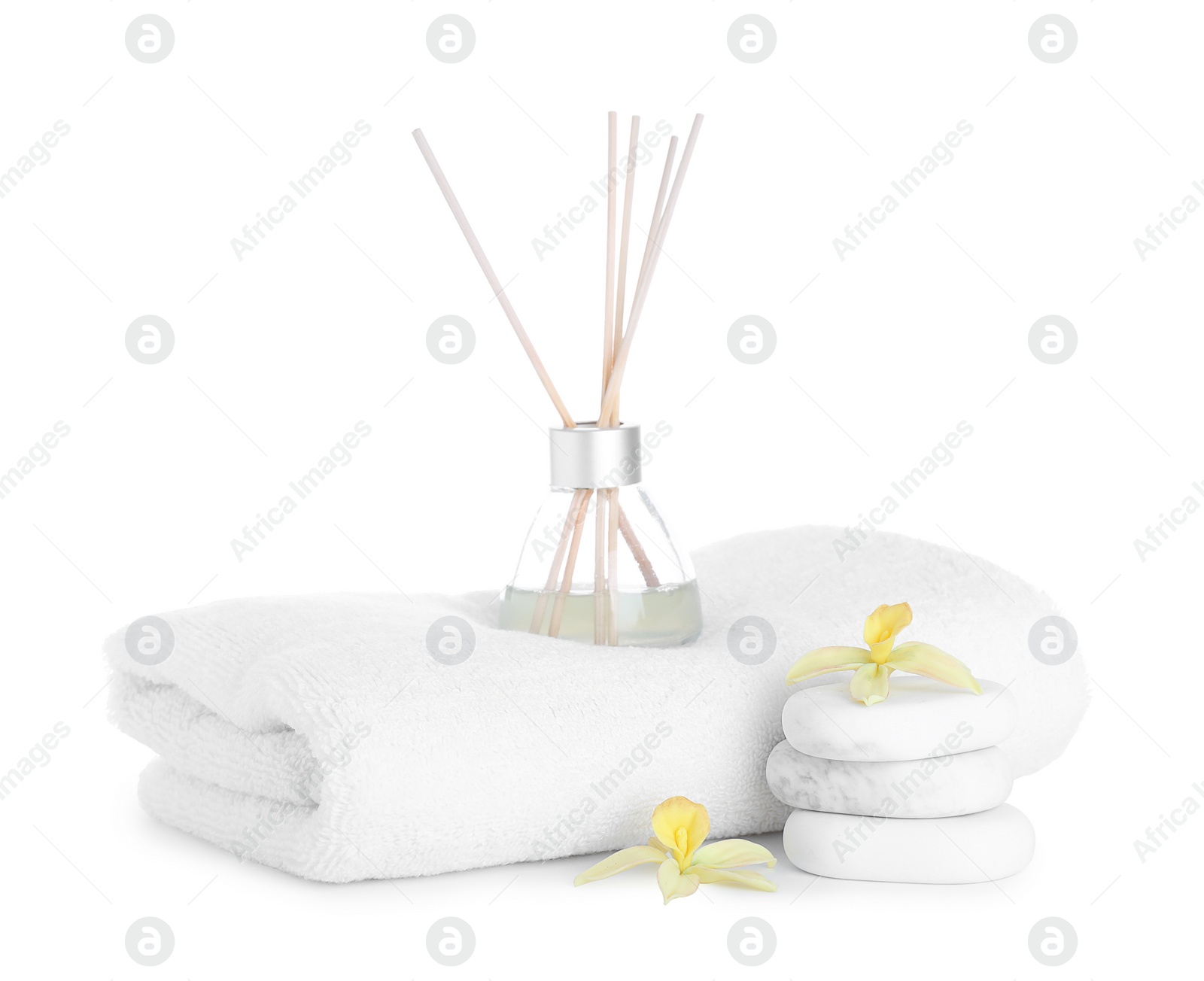 Photo of Towel, air freshener, flowers and spa stones isolated on white