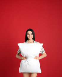 Photo of Young woman with pillow on red background