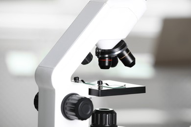 Photo of Modern medical microscope with glass slide on blurred background, closeup. Laboratory equipment