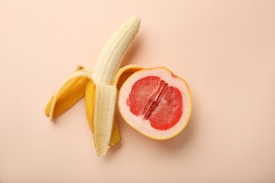 Photo of Banana and half of grapefruit on beige background, flat lay. Sex concept