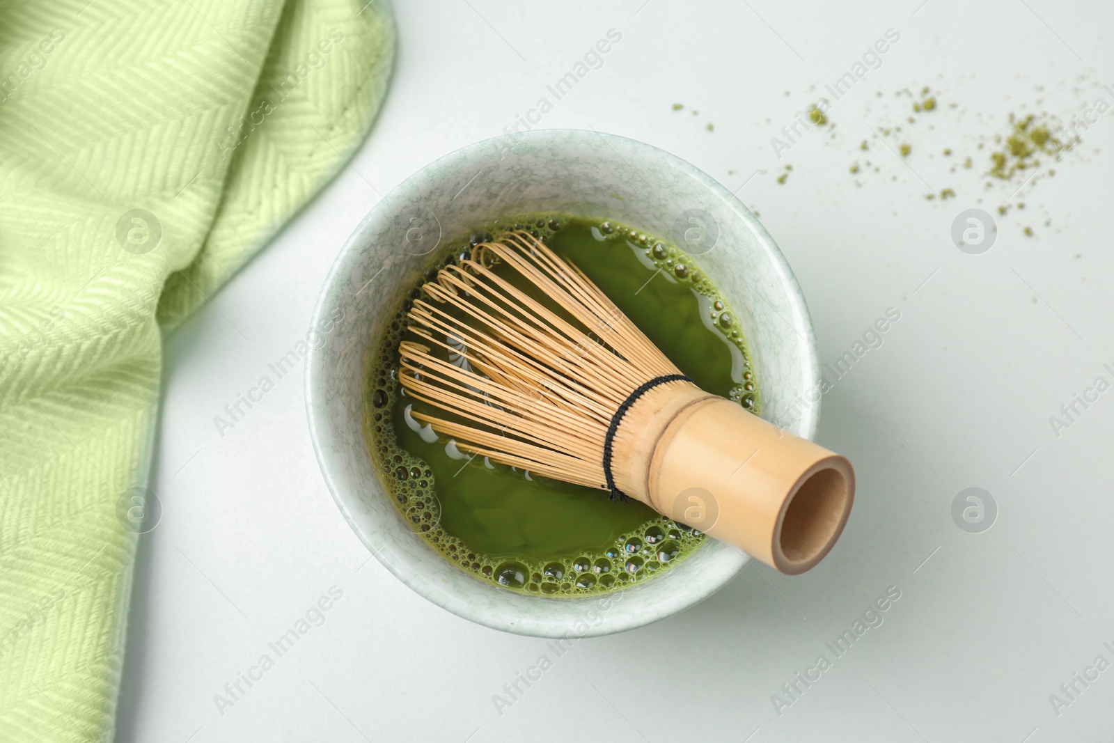 Photo of Chawan with fresh matcha tea and chasen on table, top view