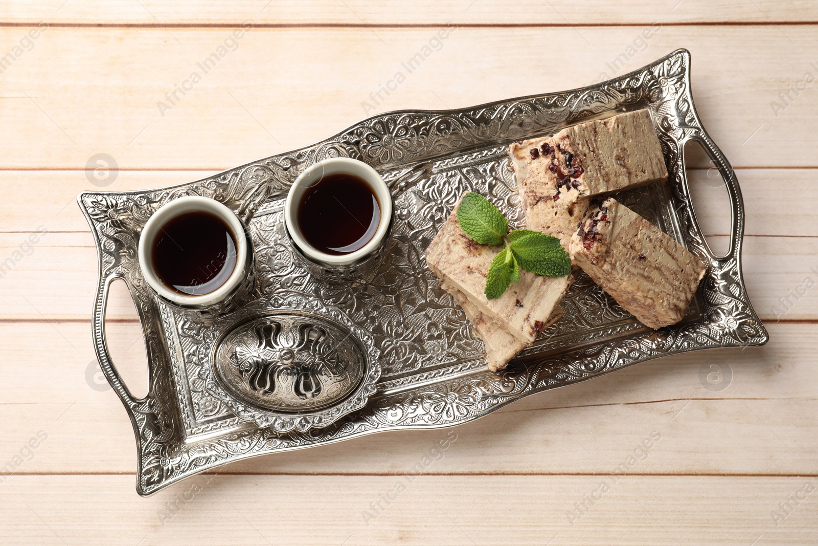 Photo of Tasty chocolate halva served on wooden table, top view