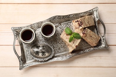 Photo of Tasty chocolate halva served on wooden table, top view