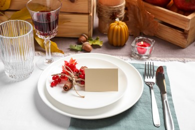 Beautiful autumn place setting with blank card and decor on table