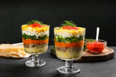 Photo of Traditional russian salad Mimosa served on black table