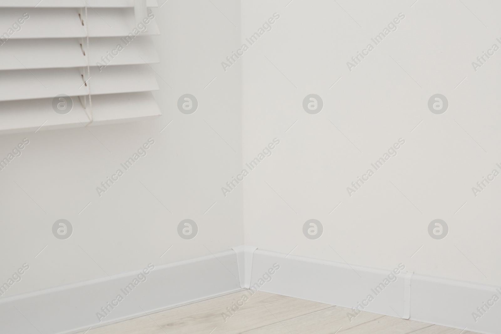Photo of Corner of white wall with baseboard indoors