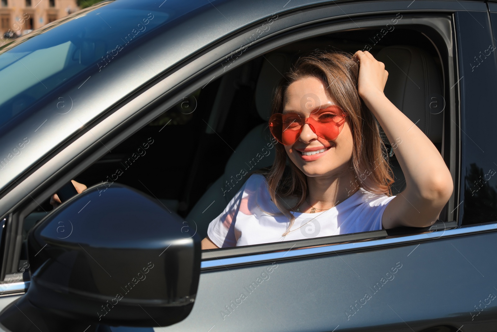 Photo of Happy woman with heart shaped glasses in car