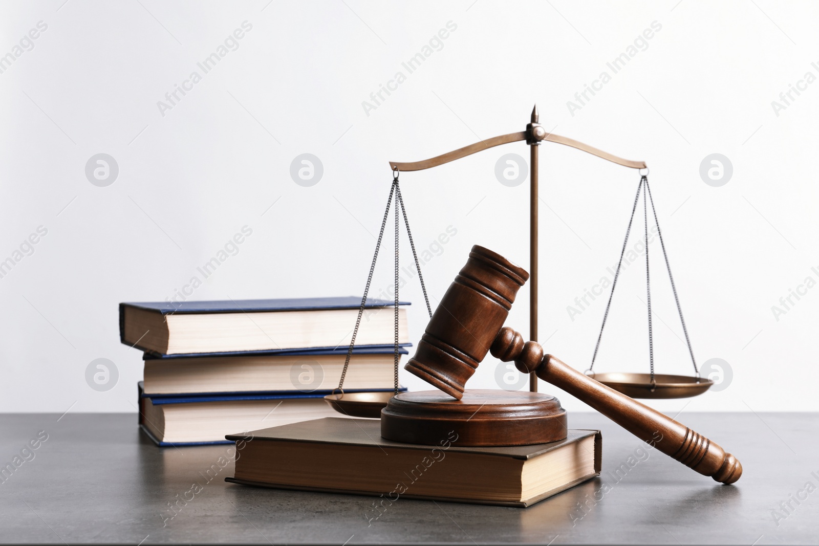 Photo of Wooden gavel, scales of justice and books on table. Law concept