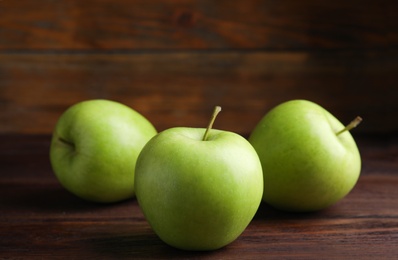 Fresh ripe green apples on wooden table, closeup