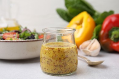 Photo of Tasty vinegar based sauce (Vinaigrette) in jar on light table, closeup