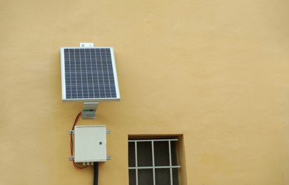 Solar panel on beige wall of building outdoors