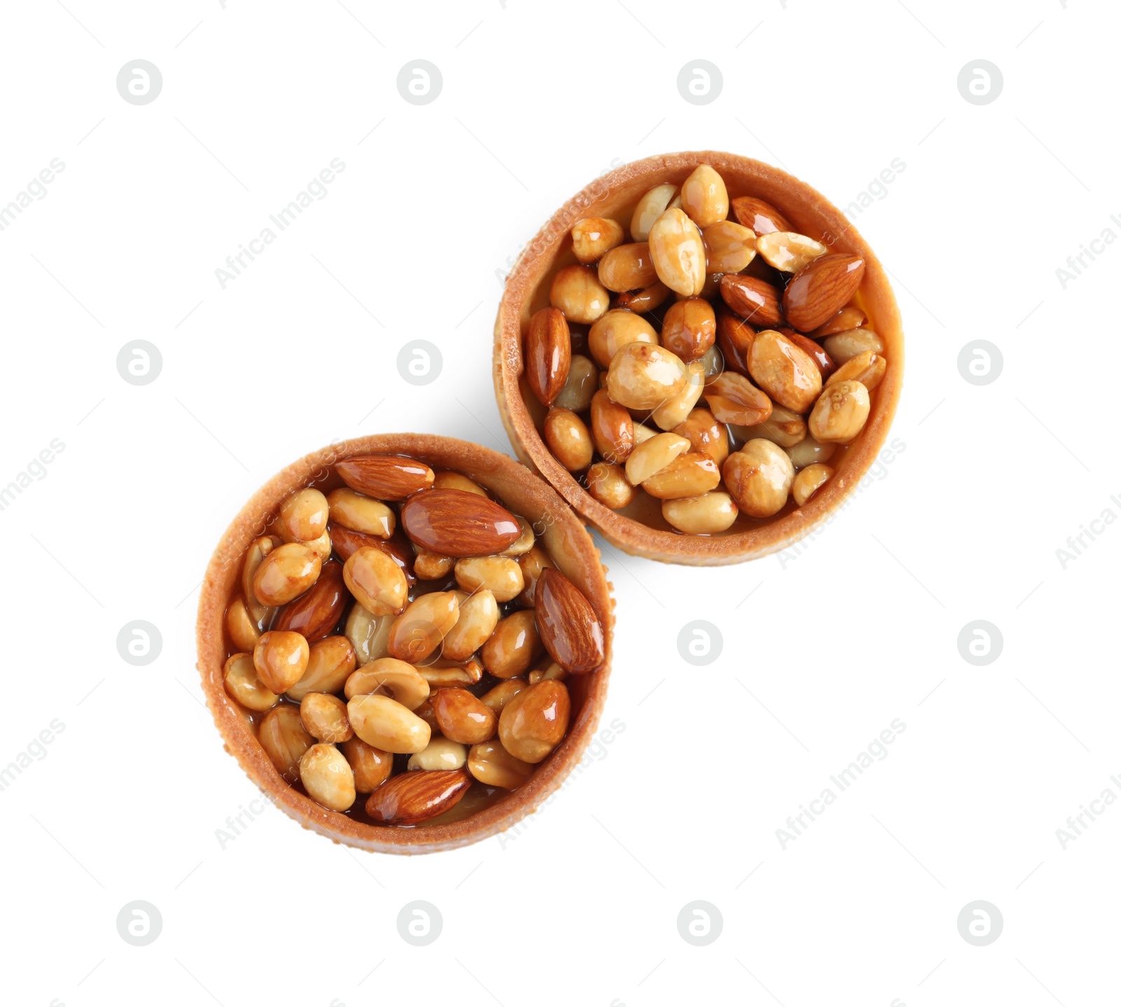 Photo of Tartlets with caramelized nuts isolated on white, top view. Tasty dessert