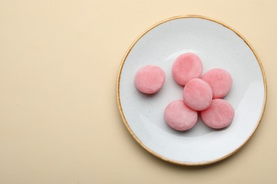 Plate with delicious mochi on beige background, top view. Space for text